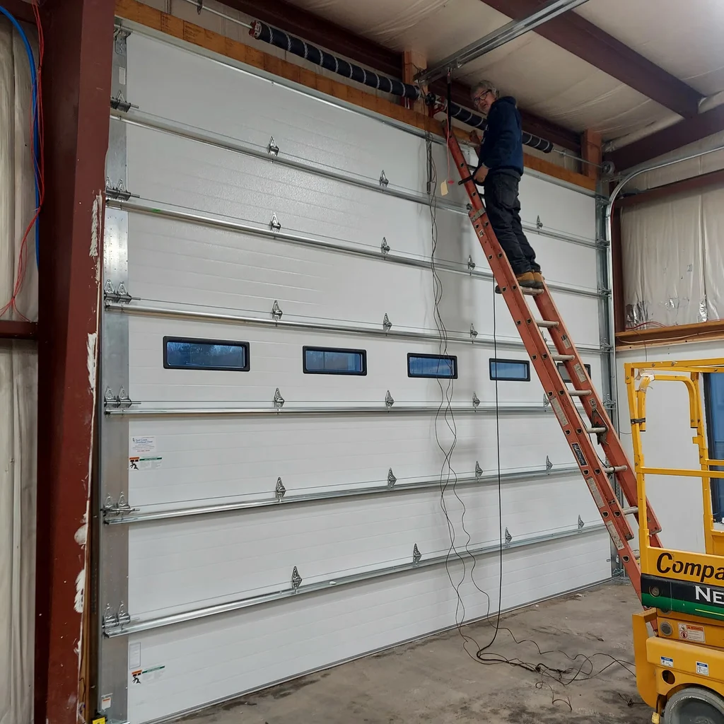 Technician reviewing a commercial overhead door assembly